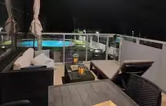 Terraza de noche con piscina iluminada