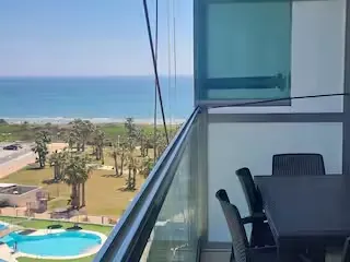Terraza acristalada con mesa y vistas al Mediterráneo